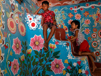 Children play inside a colorfully painted house in alpona village in chapainawabganj, Bangladesh. (