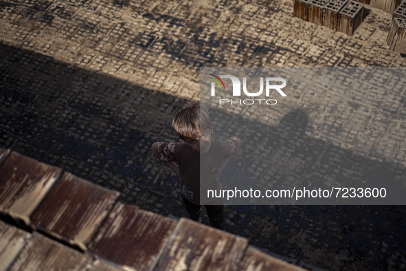 A young Afghan refugee boy looks on as he stands in a brick factory, in the Borkhar area in the west of the city of Isfahan 439Km (273 Miles...