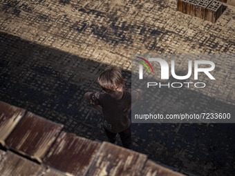 A young Afghan refugee boy looks on as he stands in a brick factory, in the Borkhar area in the west of the city of Isfahan 439Km (273 Miles...