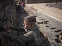 A young Afghan refugee labor piles up bricks after removing them from a kiln in a brick factory, in the Borkhar area in the west of the city...