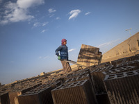 An Afghan refugee labor carrying newly bricks to a kiln in a brick factory, in the Borkhar area in the west of the city of Isfahan 439Km (27...