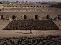 An Afghan refugee labor walks past newly bricks while working in a brick factory in the Borkhar area in the west of the city of Isfahan 439K...