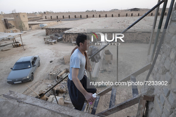 An Afghan refugee labor wearing clean clothes climbs stairs after taking shower in a brick factory after a working day in the Borkhar area i...