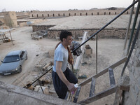 An Afghan refugee labor wearing clean clothes climbs stairs after taking shower in a brick factory after a working day in the Borkhar area i...