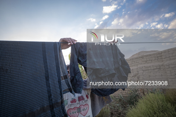 An Afghan refugee labor hangs his washed clothes from a rope out of his hut which is shared with five other Afghan laborers in a brick facto...