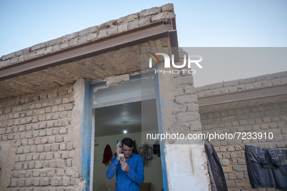 An Afghan refugee labor combs his hair as he stands at his hut which is shared with five other Afghan laborers in a brick factory after a wo...