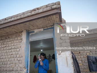 An Afghan refugee labor combs his hair as he stands at his hut which is shared with five other Afghan laborers in a brick factory after a wo...