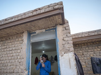 An Afghan refugee labor combs his hair as he stands at his hut which is shared with five other Afghan laborers in a brick factory after a wo...