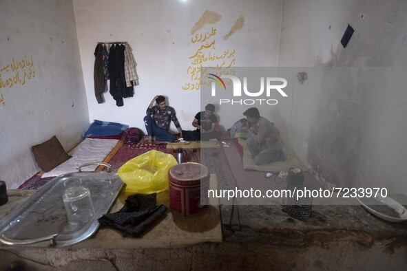 Afghan refugee laborers speak with each other as they sit at a hut in a brick factory after a working day in the Borkhar area in the west of...