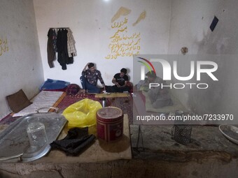 Afghan refugee laborers speak with each other as they sit at a hut in a brick factory after a working day in the Borkhar area in the west of...