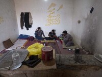 Afghan refugee laborers speak with each other as they sit at a hut in a brick factory after a working day in the Borkhar area in the west of...