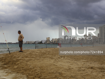 A man fishes on a beach in front of abandoned hotels fenced in by the Turkish military since 1974, in an abandoned coastal area of Varosha,...