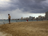 A man fishes on a beach in front of abandoned hotels fenced in by the Turkish military since 1974, in an abandoned coastal area of Varosha,...