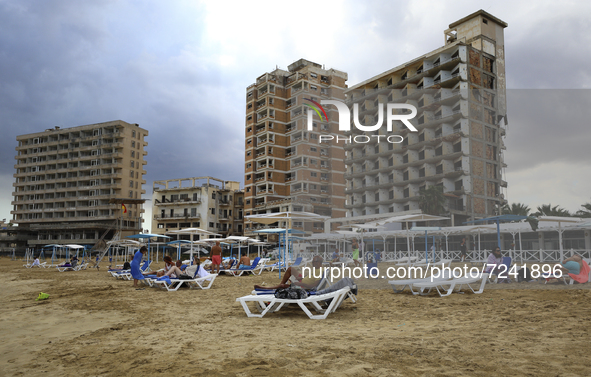 Tourists relax on a beach fenced by the Turkish military since 1974 in the abandoned coastal area of Varosha, a suburb of the city of Famagu...