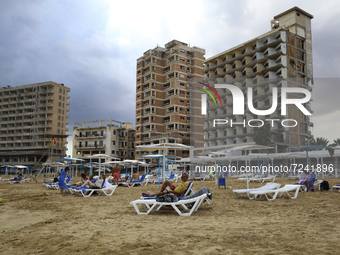 Tourists relax on a beach fenced by the Turkish military since 1974 in the abandoned coastal area of Varosha, a suburb of the city of Famagu...