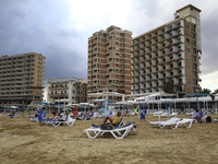 Tourists relax on a beach fenced by the Turkish military since 1974 in the abandoned coastal area of Varosha, a suburb of the city of Famagu...