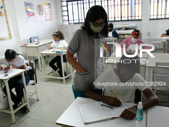 A teacher supervises a child during the start of face-to-face classes at all levels amid the Coronavirus pandemic in Caracas, Venezuela Octo...