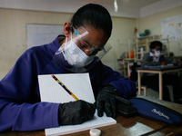 A girl copies in her notebook during the start of face-to-face classes at all levels amidst the Coronavirus pandemic in Caracas, Venezuela O...