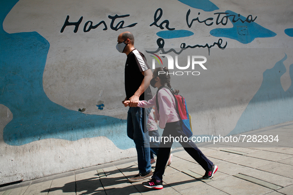 A man walks with a girl out of school during the start of on-site classes at all levels amid the Coronavirus pandemic in Caracas, Venezuela...