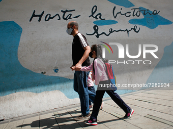 A man walks with a girl out of school during the start of on-site classes at all levels amid the Coronavirus pandemic in Caracas, Venezuela...