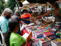 A vendor hands a pencil to a customer at a school fair in the midst of the Coronavirus pandemic in Caracas, Venezuela on October 25, 2021. (