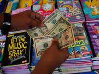 A school supplies vendor counts U.S. dollars after making a sale in the midst of the Coronavirus pandemic in Caracas, Venezuela October 25,...