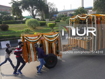 People participate as officials escort the vehicle covered with flowers carrying the casket of India's Chief of Defence Staff General Bipin...