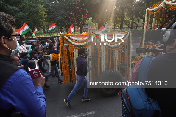 People participate as officials escort the vehicle covered with flowers carrying the casket of India's Chief of Defence Staff General Bipin...