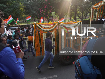 People participate as officials escort the vehicle covered with flowers carrying the casket of India's Chief of Defence Staff General Bipin...