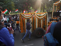 People participate as officials escort the vehicle covered with flowers carrying the casket of India's Chief of Defence Staff General Bipin...