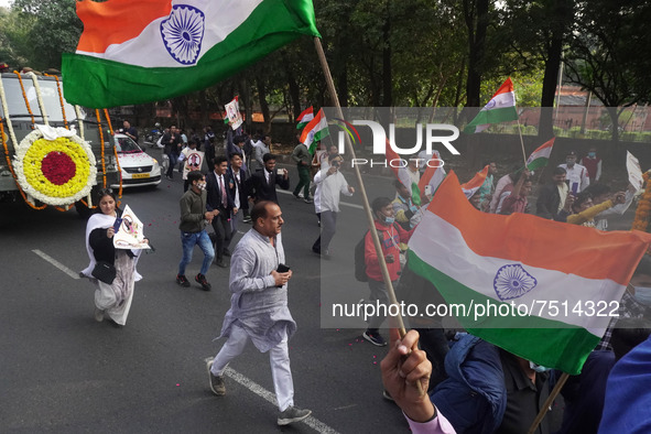 People participate as officials escort the vehicle covered with flowers carrying the casket of India's Chief of Defence Staff General Bipin...