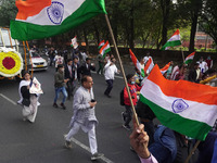 People participate as officials escort the vehicle covered with flowers carrying the casket of India's Chief of Defence Staff General Bipin...