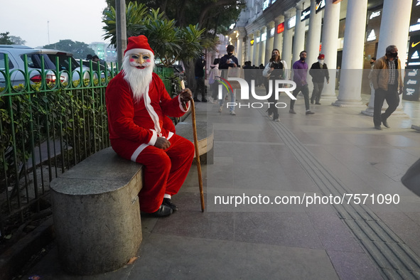 A man dressed as Santa Claus sits on a bench at a marketplace on the eve of Christmas, amidst the coronavirus (COVID-19) pandemic, in New De...