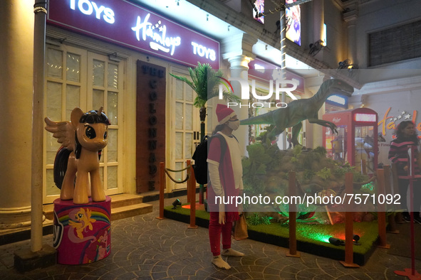 A girl dressed as Santa Claus stands outside a store on the eve of Christmas, amidst the coronavirus (COVID-19) pandemic, in New Delhi, Indi...