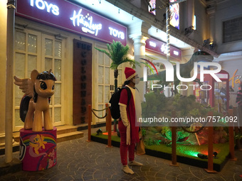 A girl dressed as Santa Claus stands outside a store on the eve of Christmas, amidst the coronavirus (COVID-19) pandemic, in New Delhi, Indi...