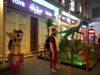 A girl dressed as Santa Claus stands outside a store on the eve of Christmas, amidst the coronavirus (COVID-19) pandemic, in New Delhi, Indi...