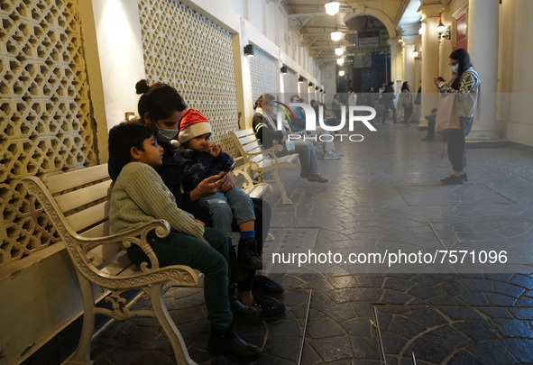 A girl wearing a Santa hat sits with her mother in a decorated alley on the eve of Christmas, amidst the coronavirus (COVID-19) pandemic, in...