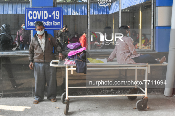 A patient is seen waiting outside a COVID-19 testing center in Kolkata , India , on 31 January 2022 .India recorded over 2 Lakh cases yester...