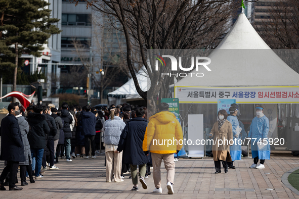 People wait in line at a COVID-19 testing facility at outside of the Seoul City Hall on February 9, 2022 in Seoul, South Korea. South Koreas...