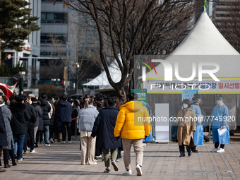 People wait in line at a COVID-19 testing facility at outside of the Seoul City Hall on February 9, 2022 in Seoul, South Korea. South Koreas...