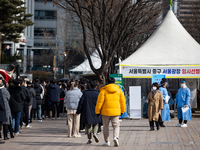 People wait in line at a COVID-19 testing facility at outside of the Seoul City Hall on February 9, 2022 in Seoul, South Korea. South Koreas...