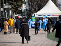 People wait in line at a COVID-19 testing facility at outside of the Seoul City Hall on February 9, 2022 in Seoul, South Korea. South Koreas...