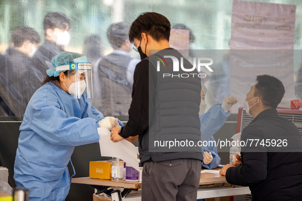 Citizens take a COVID-19 test at testing facility at Seoul Metropolitan Government Hall on February 9, 2022 in Seoul, South Korea. According...