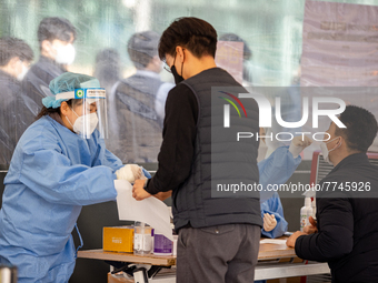 Citizens take a COVID-19 test at testing facility at Seoul Metropolitan Government Hall on February 9, 2022 in Seoul, South Korea. According...