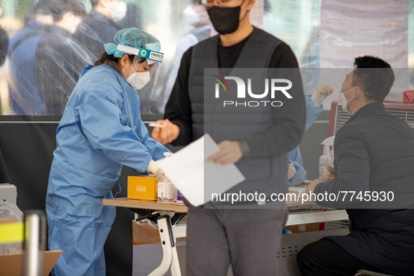 Citizens take a COVID-19 test at testing facility at Seoul Metropolitan Government Hall on February 9, 2022 in Seoul, South Korea. According...