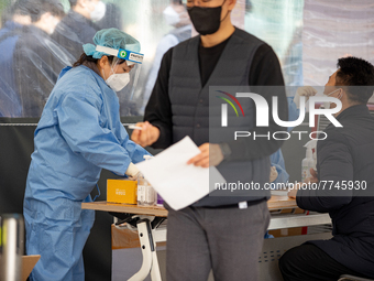 Citizens take a COVID-19 test at testing facility at Seoul Metropolitan Government Hall on February 9, 2022 in Seoul, South Korea. According...