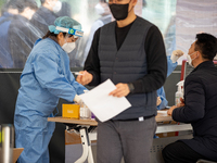 Citizens take a COVID-19 test at testing facility at Seoul Metropolitan Government Hall on February 9, 2022 in Seoul, South Korea. According...