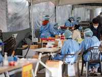 Citizens take a COVID-19 test at testing facility at Seoul Metropolitan Government Hall on February 9, 2022 in Seoul, South Korea. According...