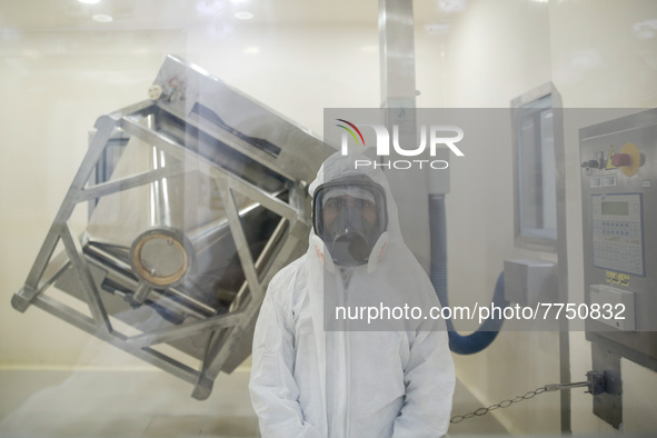 Laboratory technicians wearing full face masks and protective suits work to produce molnupiravir, the first tablet drug used to treat corona...