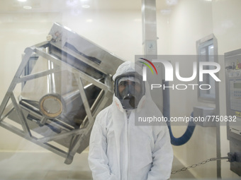 Laboratory technicians wearing full face masks and protective suits work to produce molnupiravir, the first tablet drug used to treat corona...